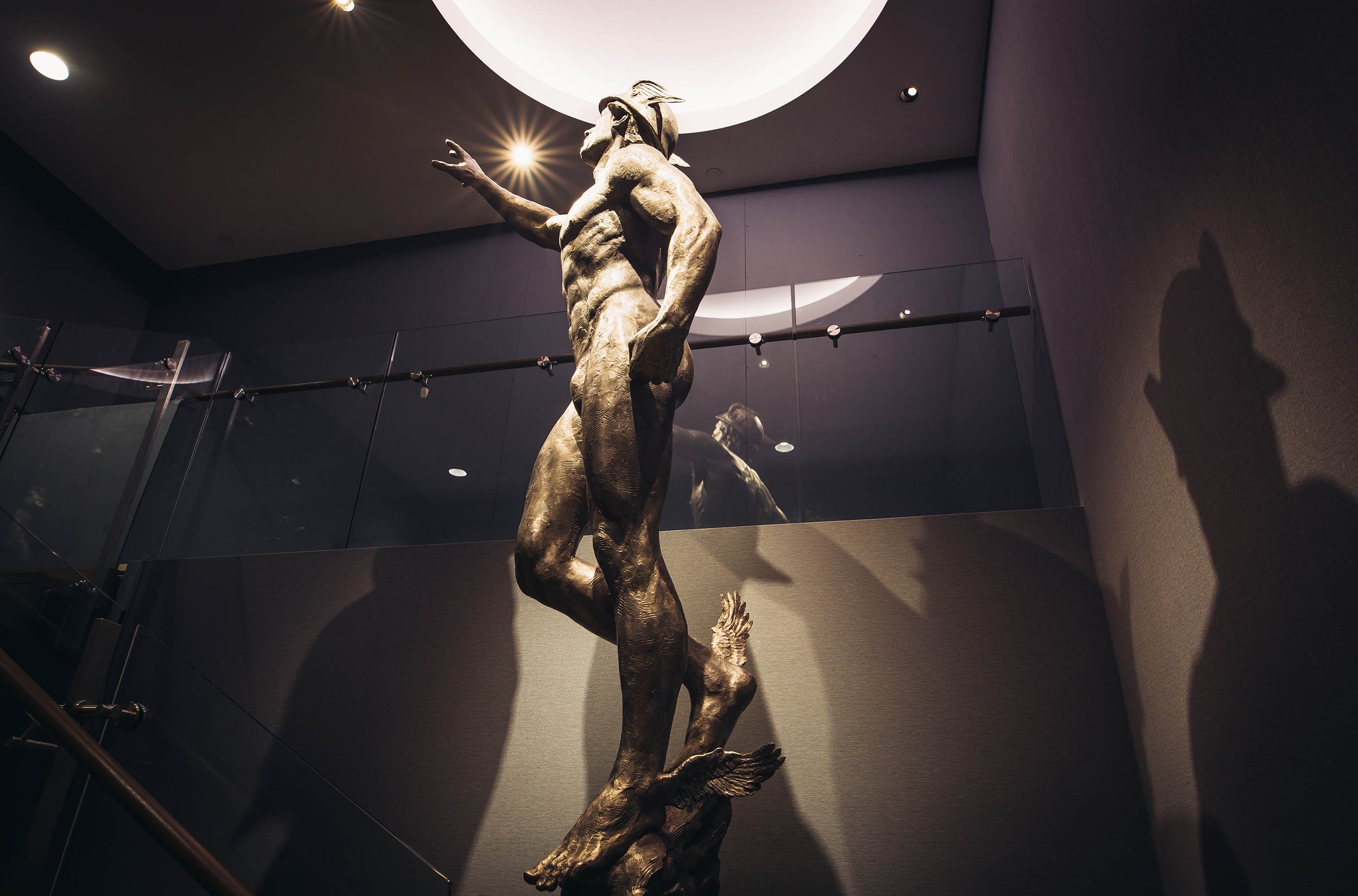 Los Angeles Athletic Club statue in a room with a spotlight above him, creating a dramatic ambiance.